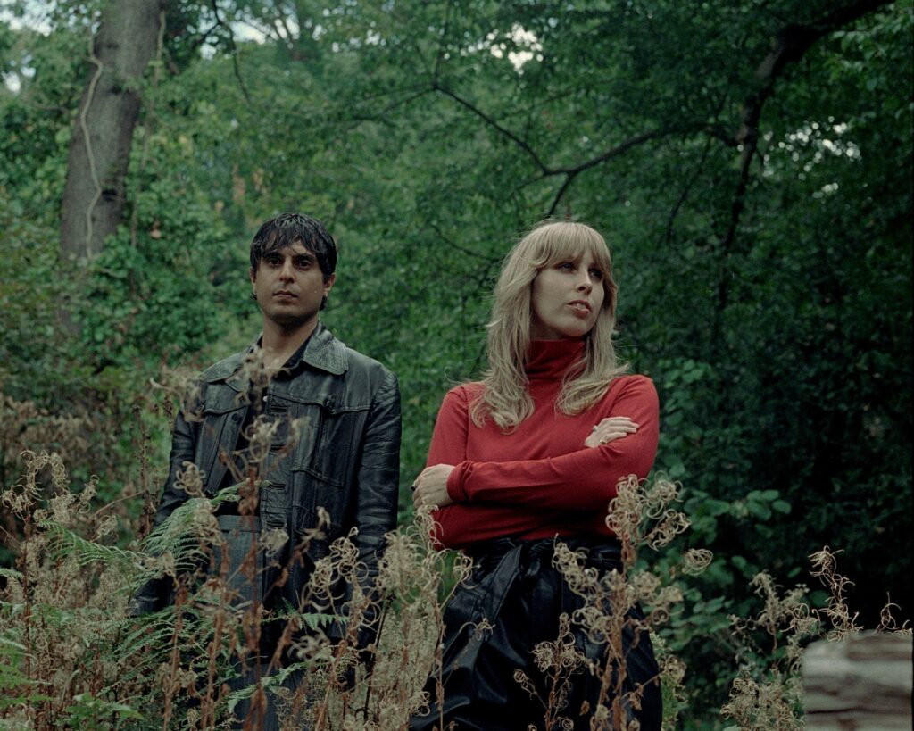 2 piece Wings of Desire stand in a woodland area behind a bush